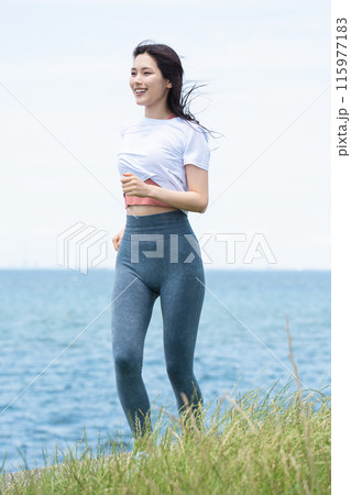 海辺をジョギングする若い女性 115977183