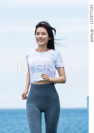 海辺をジョギングする若い女性 海辺をジョギングする若い女性 115977185