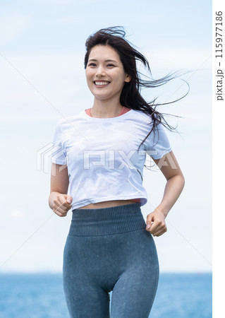 海辺をジョギングする若い女性 115977186