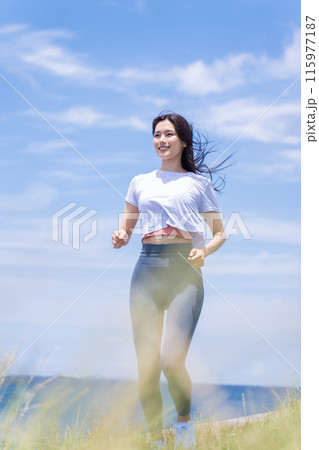 海辺をジョギングする若い女性 115977187