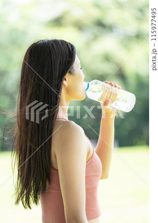 緑豊かな公園で水分補給をする女性(屋外ポートレート、休憩、リラックス) 緑豊かな公園で水分補給をする女性(屋外ポートレート、休憩、リラックス) 115977495