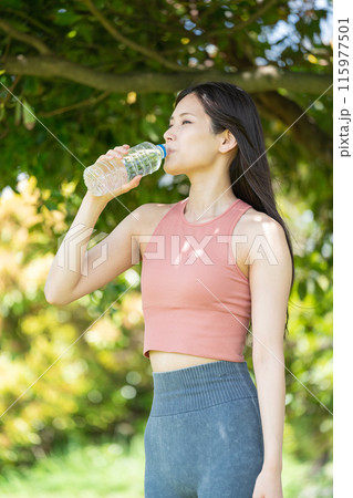 緑豊かな公園で水分補給をする女性(屋外ポートレート、休憩、リラックス) 緑豊かな公園で水分補給をする女性(屋外ポートレート、休憩、リラックス) 115977501