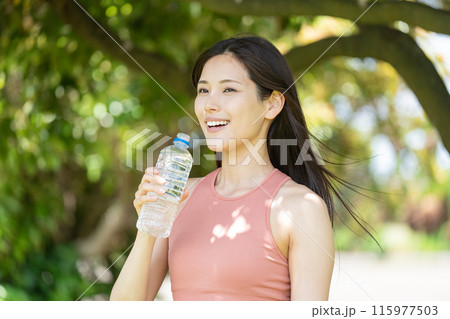 緑豊かな公園で水分補給をする女性(屋外ポートレート、休憩、リラックス) 緑豊かな公園で水分補給をする女性(屋外ポートレート、休憩、リラックス) 115977503
