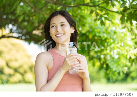 緑豊かな公園で水分補給をする女性(屋外ポートレート、休憩、リラックス) 緑豊かな公園で水分補給をする女性(屋外ポートレート、休憩、リラックス) 115977507