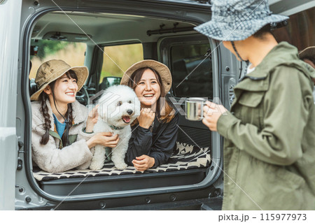 愛犬・ペットと一緒にキャンプ・デイキャンプ・ドライブするアウトドアファッションの女性・友達・親友 115977973