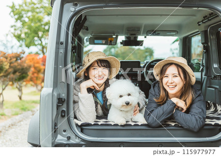 愛犬・ペットと一緒にキャンプ・デイキャンプ・ドライブするアウトドアファッションの女性・友達・親友 115977977