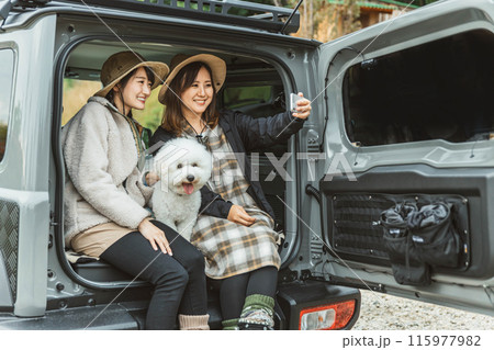 愛犬・ペットと一緒にドライブするアウトドアファッションの女性・友達・親友 愛犬・ペットと一緒にドライブするアウトドアファッションの女性・友達・親友 115977982