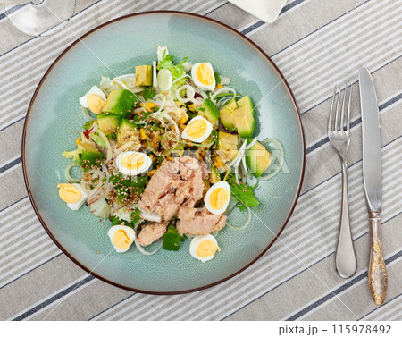 Tuna salad with avocado, eggs and greens on ceramic plate 115978492