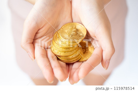Someone hand holding some pieces of golden Bitcoin token isolated on white background. Someone hand holding some pieces of golden Bitcoin token isolated on white background. 115978514