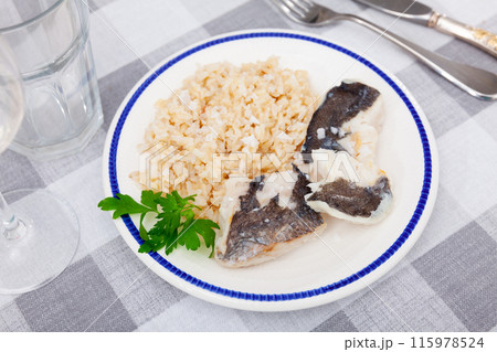 Tender meat of baked cod fillet is garnished with boiled basmati rice. Tender meat of baked cod fillet is garnished with boiled basmati rice. 115978524