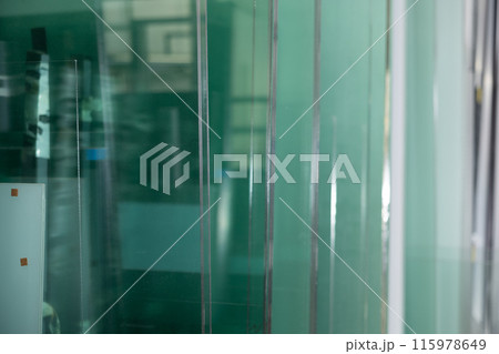 Row of finished window glass in an industrial workshop closeup Row of finished window glass in an industrial workshop closeup 115978649