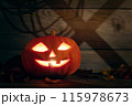 Halloween Pumpkin Jack-O-Lantern in a wooden barn with shadows on the wall 115978673