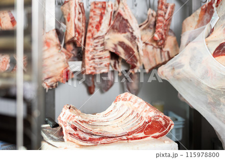 Raw beef ribs lying on cutting table in butcher shop Raw beef ribs lying on cutting table in butcher shop 115978800