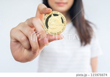 Woman holding a Dogecoin tokens. 115978874