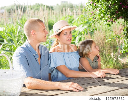 Portrait of happy family at table in courtyard of country house 115978882