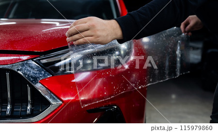 The process of applying protective vinyl film to car headlights in detailing. The process of applying protective vinyl film to car headlights in detailing. 115979860