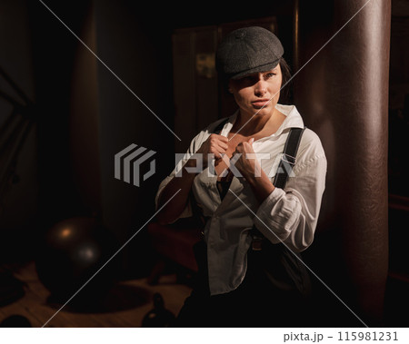 Caucasian woman in a men's suit in the style of Peaky Blinders. 115981231