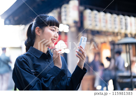 スマホを見ながら大阪観光する若い女性 スマホを見ながら大阪観光する若い女性 115981383