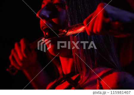 A man gags a woman. BDSM concept. A man gags a woman. BDSM concept. 115981407