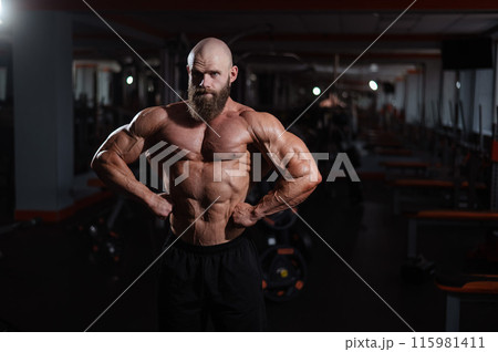 Caucasian bald man posing in the gym. Caucasian bald man posing in the gym. 115981411