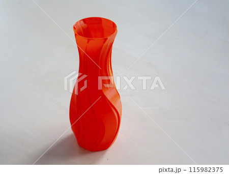 Object in the form of a vase of red color printed on a 3D printer. Three-dimensional model printed on a 3D printer from molten plastic of red color. Concept 3D Printing. FDM 3D Printing technology 115982375