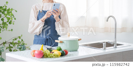 スマホで料理のレシピを調べる女性(キッチン・主婦) スマホで料理のレシピを調べる女性(キッチン・主婦) 115982742