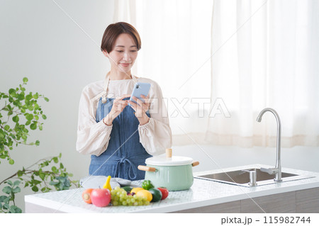 スマホで料理のレシピを調べる女性(キッチン・主婦) スマホで料理のレシピを調べる女性(キッチン・主婦) 115982744