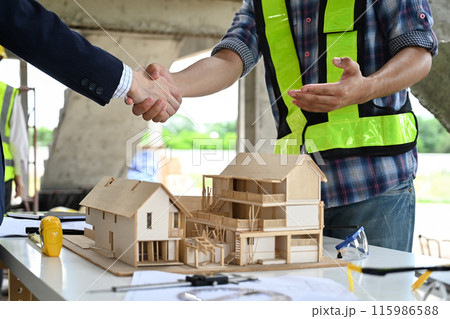 Cropped shot of building contractor shaking hands with investor at building site. Partnership and successful project Cropped shot of building contractor shaking hands with investor at building site. Partnership and successful project 115986588
