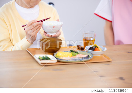 介護 食事を楽しむシニアと介護士(手元) 介護 食事を楽しむシニアと介護士(手元) 115986994