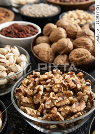 Raw walnuts and cashew with almonds and peanuts with organic nuts and seed in various assorted bowls 115987455