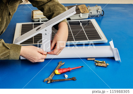 Customer assembles solar street light from flat pack, starting with mounting bracket. Customer assembles solar street light from flat pack, starting with mounting bracket. 115988305