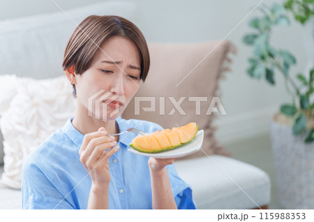 デザートのメロンを食べる女性 デザートのメロンを食べる女性 115988353