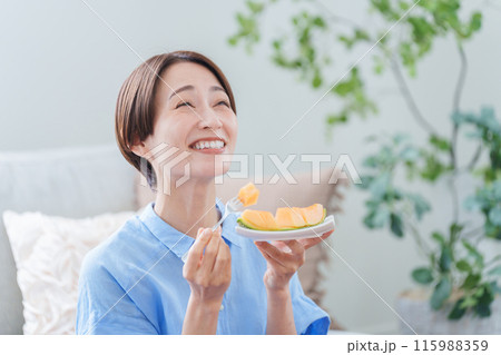 デザートのメロンを食べる女性 デザートのメロンを食べる女性 115988359