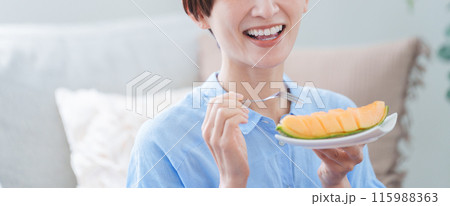 デザートのメロンを食べる女性 115988363