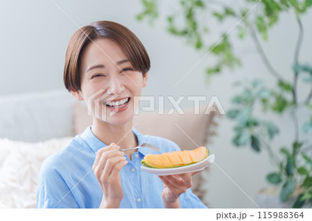 デザートのメロンを食べる女性 デザートのメロンを食べる女性 115988364