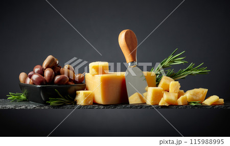 Parmesan cheese with knife, olives and rosemary. Parmesan cheese with knife, olives and rosemary. 115988995