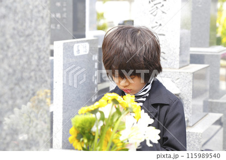 お墓の前で手を合わせる少年 お墓の前で手を合わせる少年 115989540