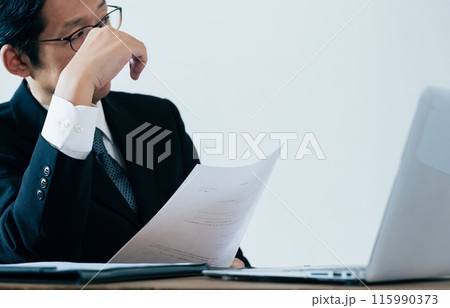 書類を見る採用担当の男性 115990373