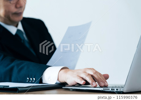 書類を見る採用担当の男性 115990376