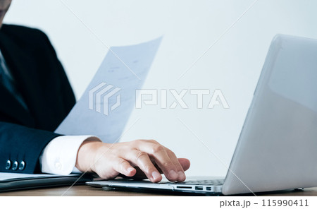 ノートパソコンで仕事をするビジネスマンの手元 115990411