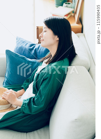 リビングのソファでくつろぐ若い女性 115990435
