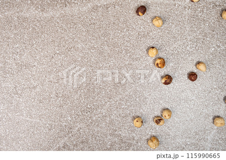 Roasted hazelnuts on a gray stone background top view, place for text 115990665