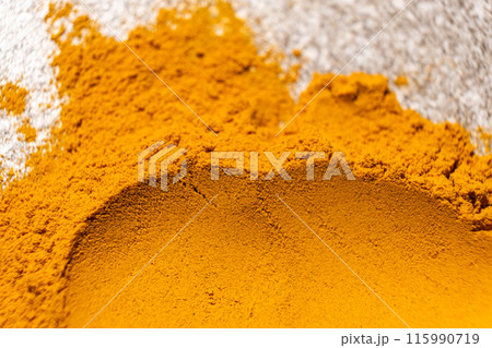 A smear of turmeric on a gray background, top view A smear of turmeric on a gray background, top view 115990719