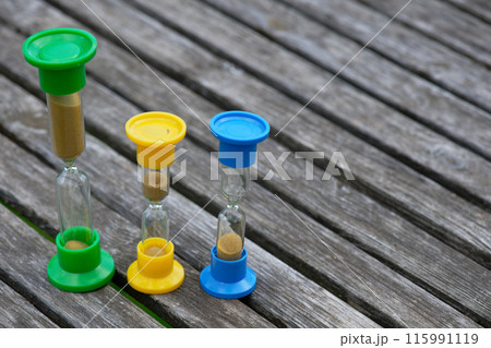 Hourglasses on rustic wooden table 115991119