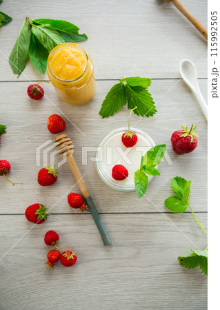 homemade sweet yogurt in a jar with strawberries, on a wooden table 115992505