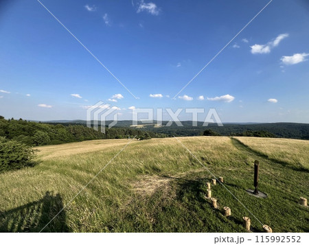 A sundial made of wooden bars in a field among greenery A sundial made of wooden bars in a field among greenery 115992552