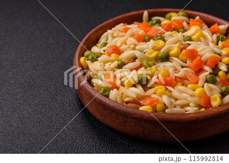 Delicious boiled rice with vegetables corn, carrots, peas with salt 115992814