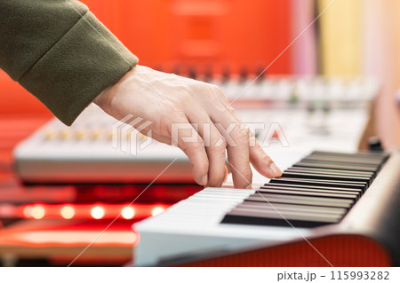male musician hand playing on piano keys in studio. music background 115993282