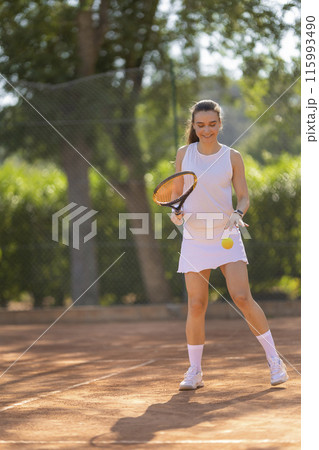 A woman is playing tennis on a court 115993490