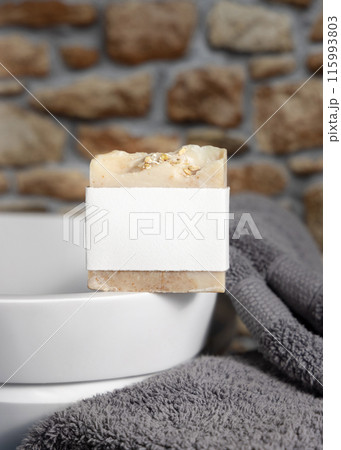 Soap bar with blank label on vessel sink near grey towels against stone wall close up, mockup Soap bar with blank label on vessel sink near grey towels against stone wall close up, mockup 115993803